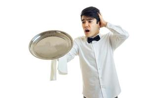 a young waiter in a white shirt stretched forward food tray and keeps the ball behind the head photo