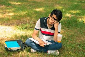 young cute guy got tired sitting on the grass photo
