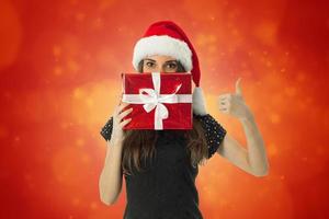 woman in santa hat with red gift photo