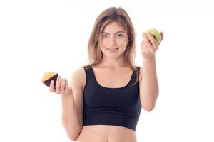 Sports girl stands up straight and holding a cupcake  Apple isolated on white background photo