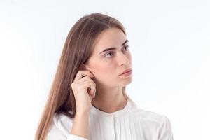 young girl looks away and keeps  hand behind his ear is isolated on  white background photo