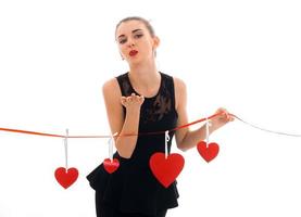 pretty young brunette woman with red lips and hearts on background isolated on white photo