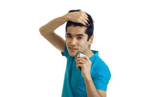 Portrait of smiling charming guy who keeps hand hair and shaves isolated on a white background photo