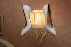 zapatos blancos de boda colgando de la lámpara foto