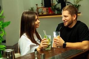 pareja enamorada sentada en el bar bebiendo cócteles foto