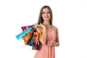 smiling young girl stands up straight looks ahead and holds in his hand the different packages with gifts is isolated on a white background photo