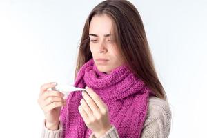 young girl with  scarf around his neck holding the thermometer photo