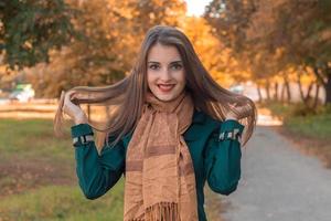 cute girl laughs and keeps hands hair in the Park photo