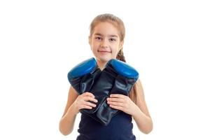 little smiling girl looking at the camera and holding a big boxing gloves photo