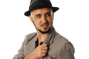 young cheerful man in hat and jacket looking aside photo