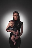 Sexy young mother with little baby girl in studio photo