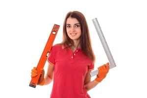 young happy builder girl in uniform makes renovation isolated on white background photo