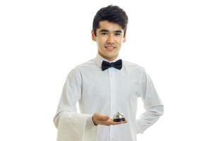 fascinating young waiter smiles and holds in his hand a call for guest photo