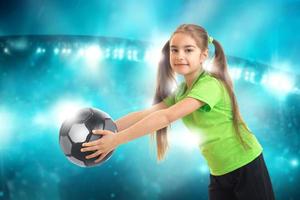 little athletic girl with ball in her hands smiles photo
