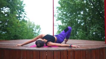 mujer realiza posturas de yoga y se estira en el escenario al aire libre video