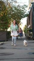 Woman walking dog on sidewalk video