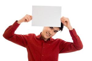 pretty young guy in red shirt with empty placard in hands posing isolated on white background photo