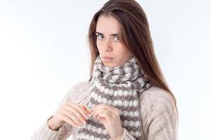 young girl stands in  sweater and warm scarf is isolated on  white background photo