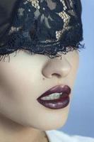 Close up of sensual young lady with purple beautiful lips and lace on eyes photo