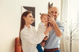 madre padre e hija pequeña posando en cámara en casa foto