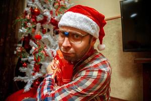 Serious nerd in santa hat gets a christmas gift photo