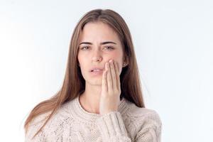 young girl have toothache and it keeps hand on cheek isolated  white background photo