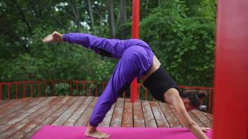 Frau führt Yoga-Posen durch und dehnt sich auf der Freilichtbühne aus video