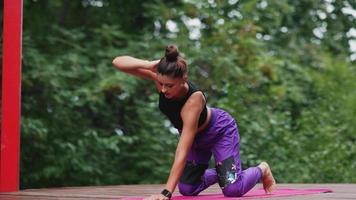 vrouw presteert yoga poses en strekt zich uit Aan buitenshuis stadium video