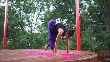 Woman performs yoga poses and stretches on outdoor stage video