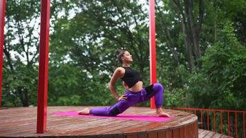 Woman performs yoga poses and stretches on outdoor stage video