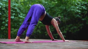 kvinna utför yoga poser och sträckor på utomhus- skede video