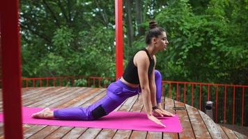 mujer realiza posturas de yoga y se estira en el escenario al aire libre video