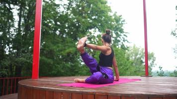 kvinna utför yoga poser och sträckor på utomhus- skede video