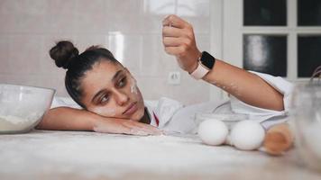 vrouw in keuken druppels meel van haar hand- video