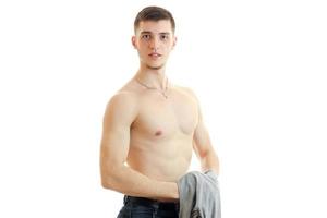 young handsome guy stands with the Bared torso holding a Mike and looks into a camera photo