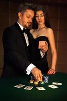 Nice man in elegant suit looking cards with his sexual woman and make big bet photo