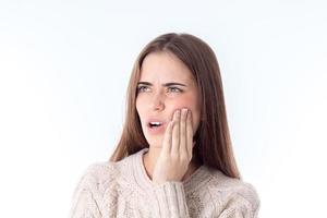 girl with severe dental pain keeps hand on cheek isolated  white background photo