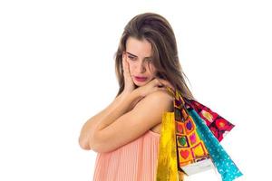 thoughtful girl raised on the shoulder of the bright bags isolated  white background photo