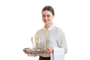Cheerful brunette waitress smiles and hold a trey with champagne photo
