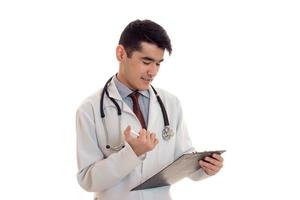 a young doctor in a white lab coat looking at Tablet isolated on white background photo