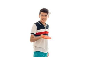 deportista alegre practicando tenis de mesa con raqueta en las manos y sonriendo a la cámara aislada de fondo blanco foto