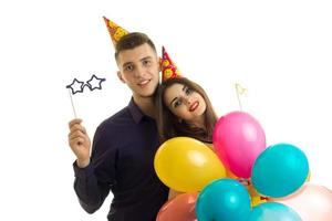 maravilloso joven con una chica mirando a la cámara sonriendo y llevando globos y transferencia de papel foto