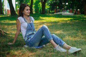 beautiful happy lady listens to music with headphones in a park photo