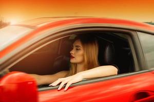 sunset portrait of young beautiful girl driving a car photo