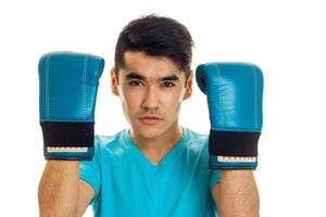 portrait of young guy practicing boxing in blue gloves isolated on white background photo