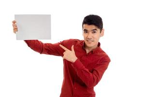 pretty young brunette man in red t-shirt with placcard in his hands isolated on white background photo