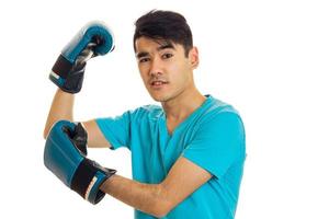 Morena joven deportista practicando boxeo en guantes azules aislado sobre fondo blanco. foto