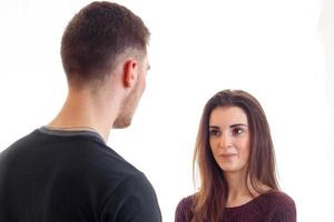 a young girl and a guy are standing and watching each other photo