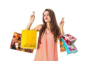 funny young girl keeps big bags with giveaways and closed her eyes isolated on white background photo