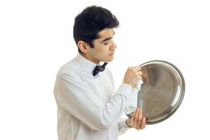 male waiter in uniform with bowtie cleans a trey photo